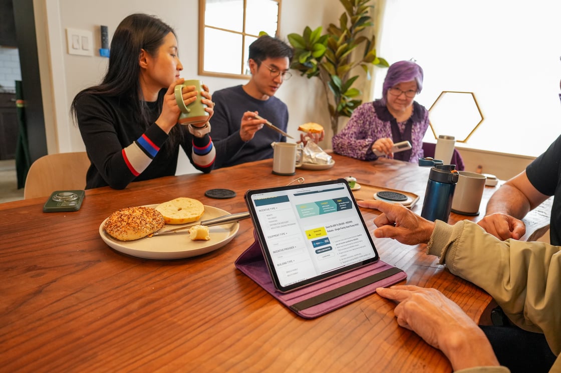 Family gathered around all-electric incentives webiste
